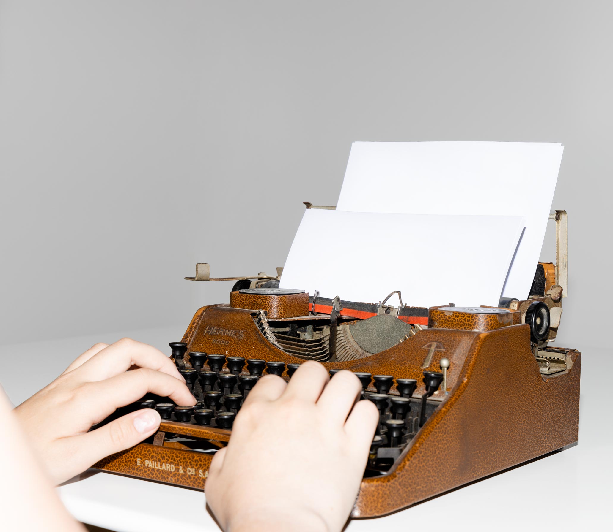 zwei Hände auf einer Schreibmaschine tippend